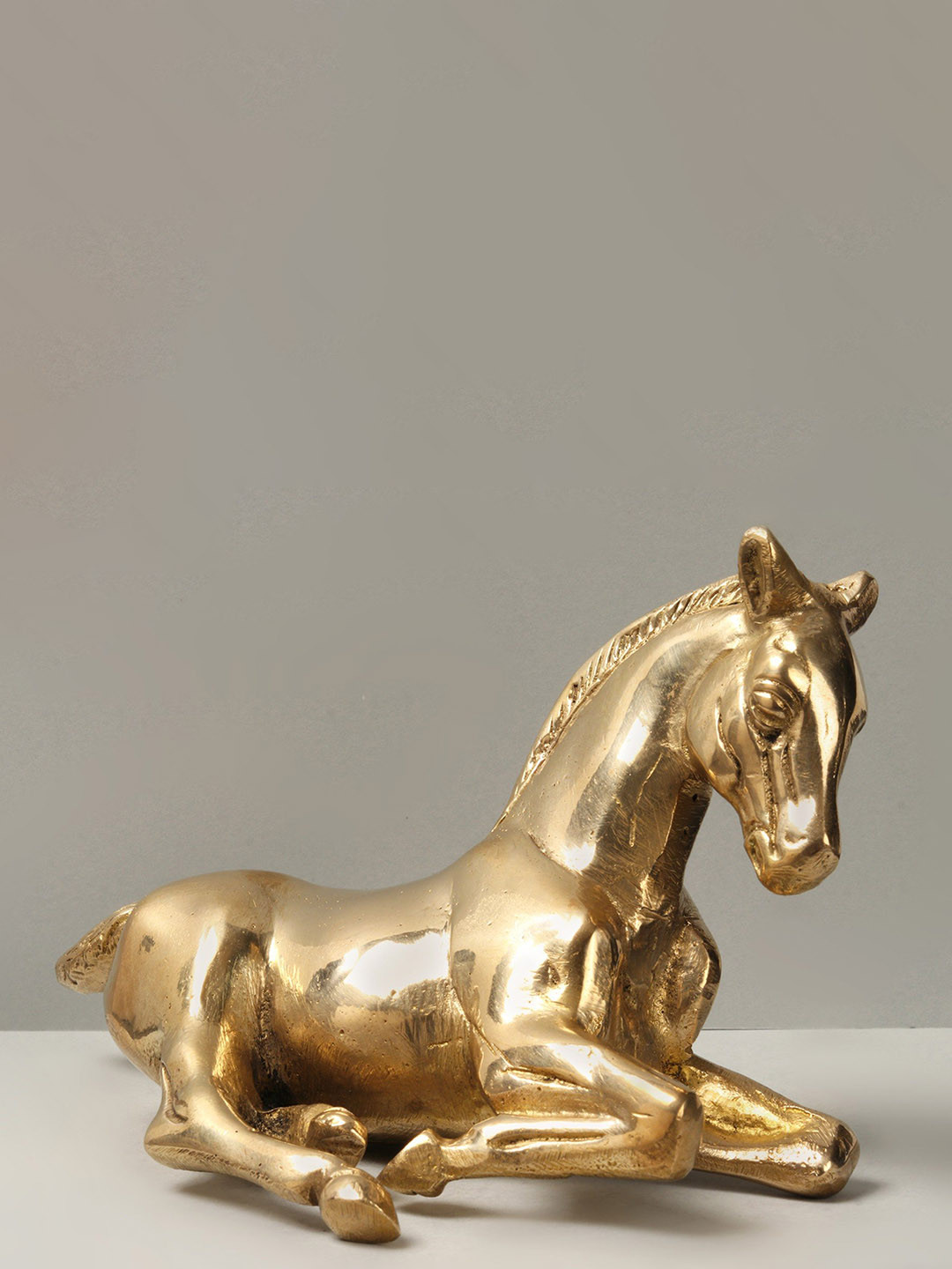 Exotic India Reclining Horse Gold Brass Metallic Living Room Small Showpiece - 4.1 Inches