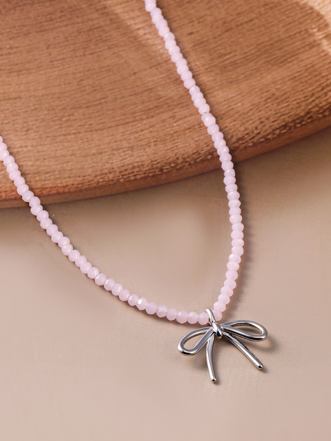Rubans Rhodium Plated Soft Pink Beaded Necklace with Silver Bow Pendant