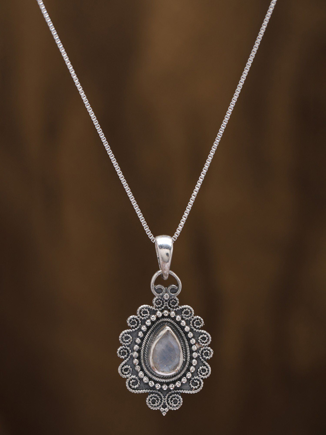 Exotic India Sterling Silver Pendant with Tear drop Shape Rainbow Moonstone