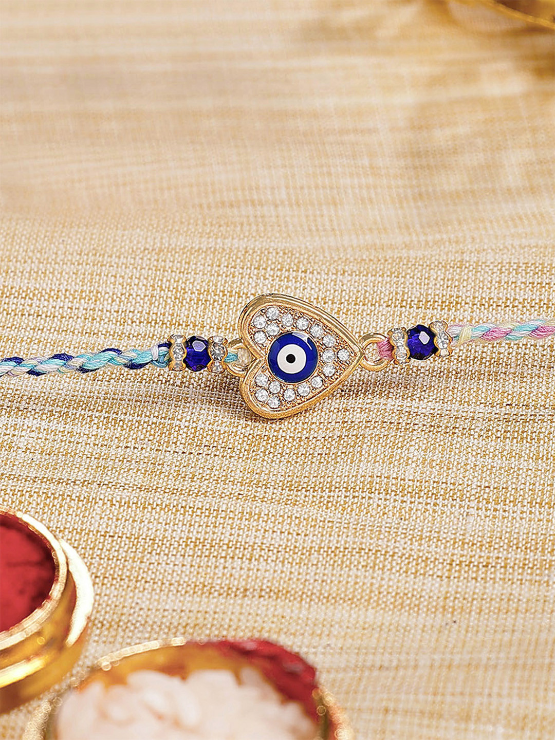 KARATCART Men Gold Plated Blue Evil Eye and American Diamond Rakhi with Roli & Chawal