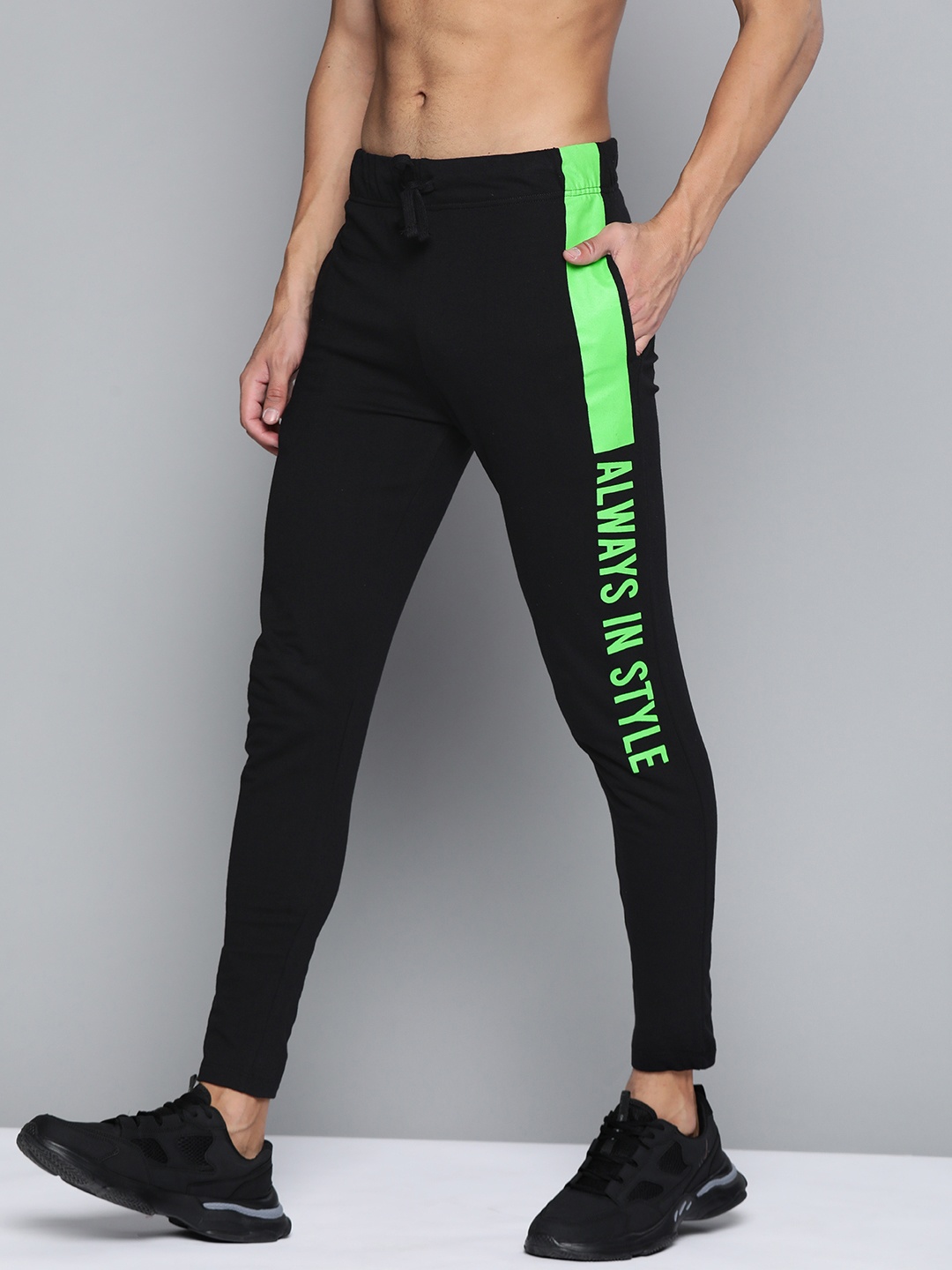 

Kook N Keech Men Black & Fluorescent Green Solid Track Pants with Typography Print Detail