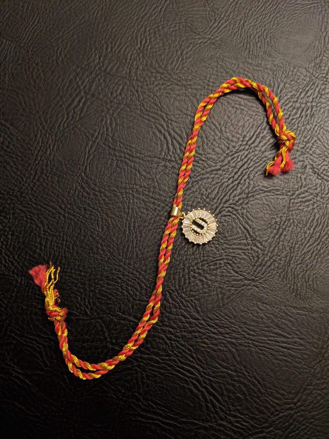 

Digital Dress Room Gold-Toned Rakhi with Letter U Slogan