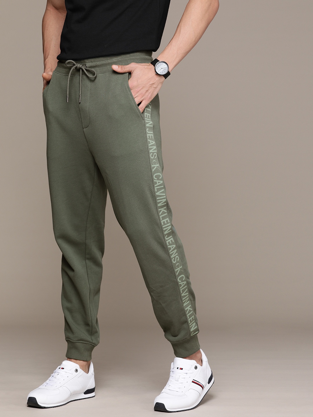 

Calvin Klein Jeans Men Olive Green Solid Slim Fit Joggers With Printed Side Stripes