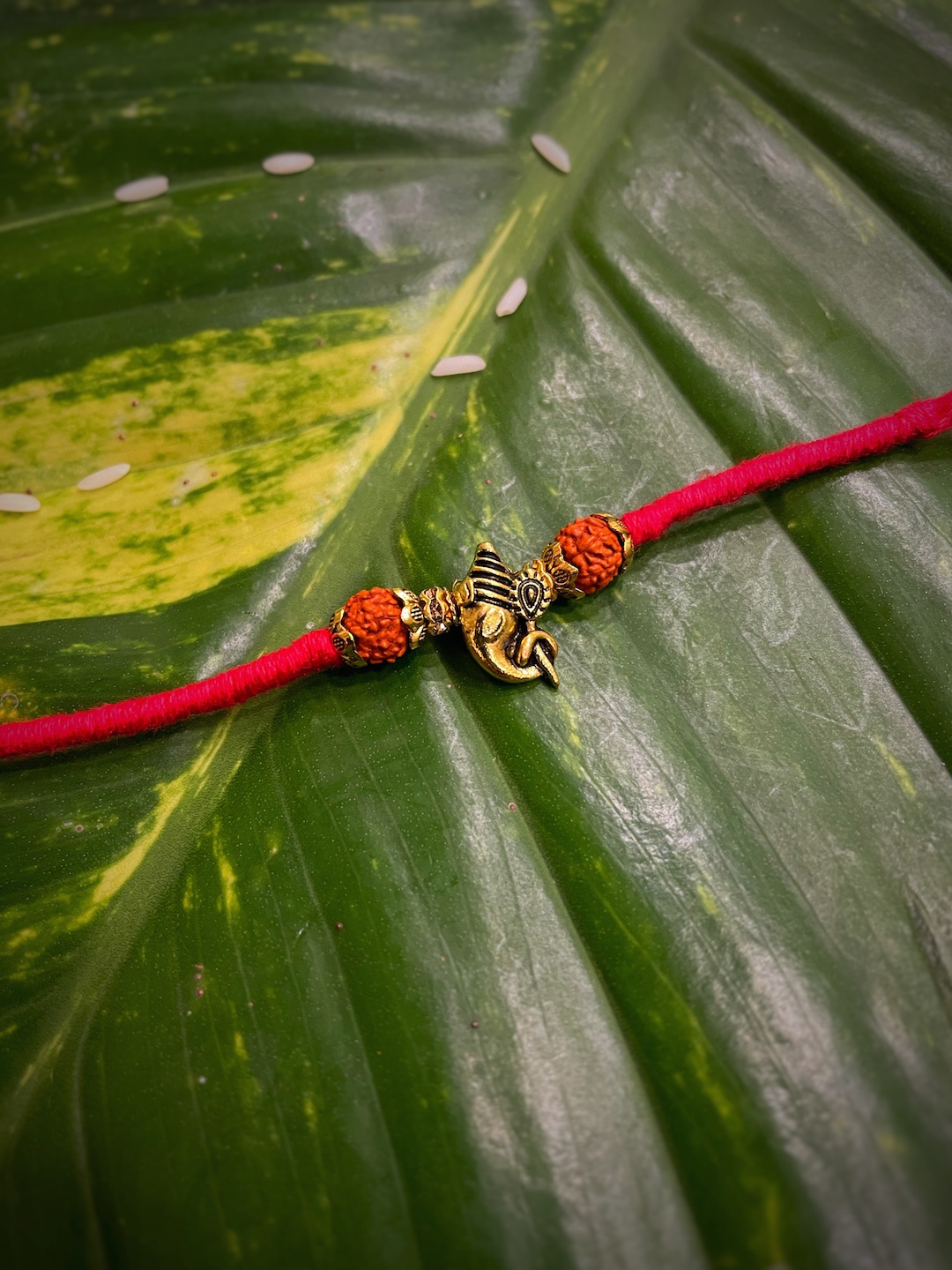 

Digital Dress Room Red & Gold Ganesh Ji Pendant with Rudhraksha Mauli Rakhi