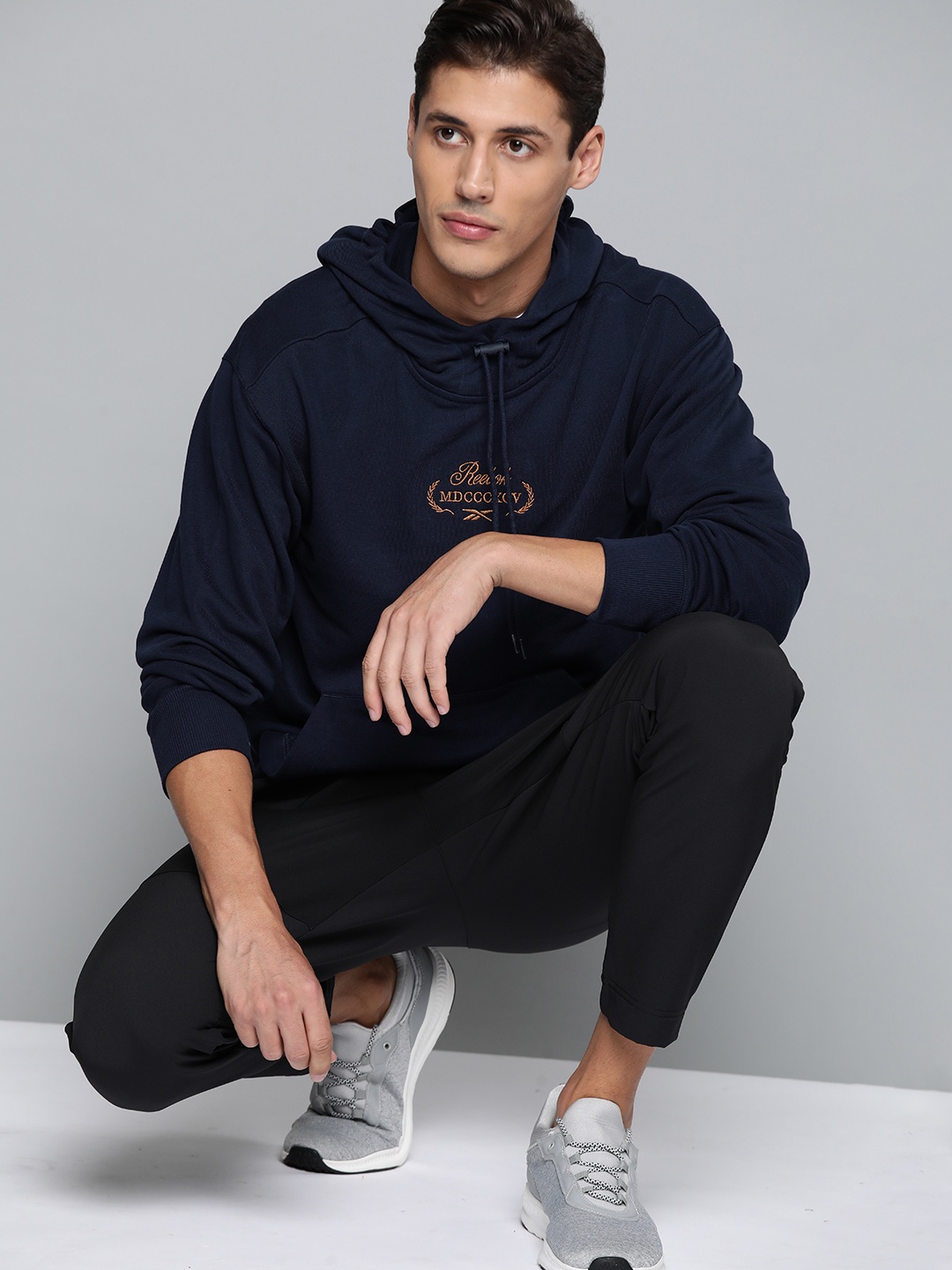 

Reebok Classic Men Navy Blue Solid Cotton Golf Graphic Hooded Sweatshirt