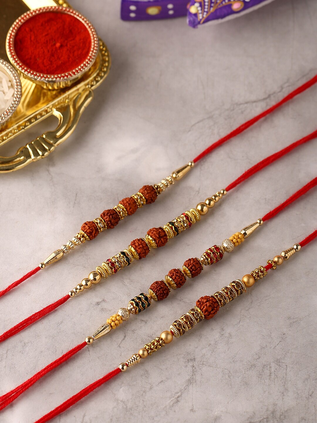 

Voylla 4 Pcs Unisex Religious Rudraksha Rakhi Squad with Roli Chaawal Pack, Gold