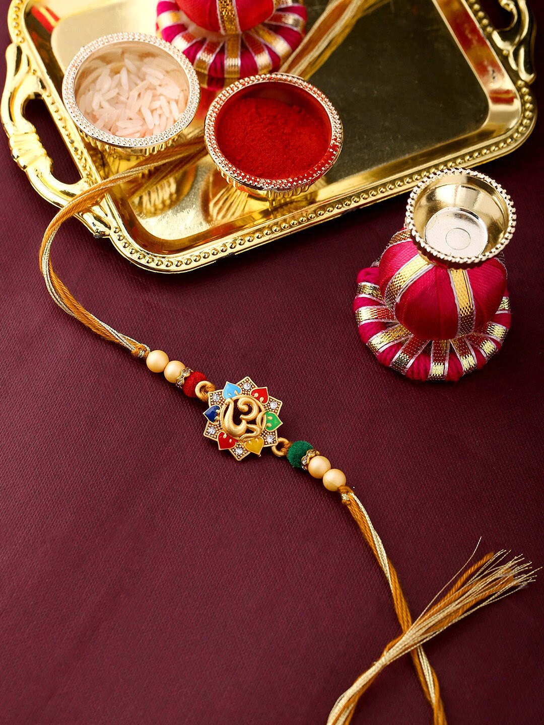 

Voylla Rudraksha OM Enameled Rakhi with Roli Chaawal Pack, Gold