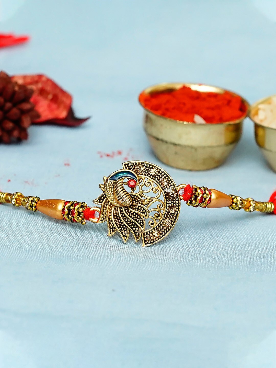 

eCraftIndia Gold-Toned & Red Designer Peocock Rakhi & Roli Chawal Pack