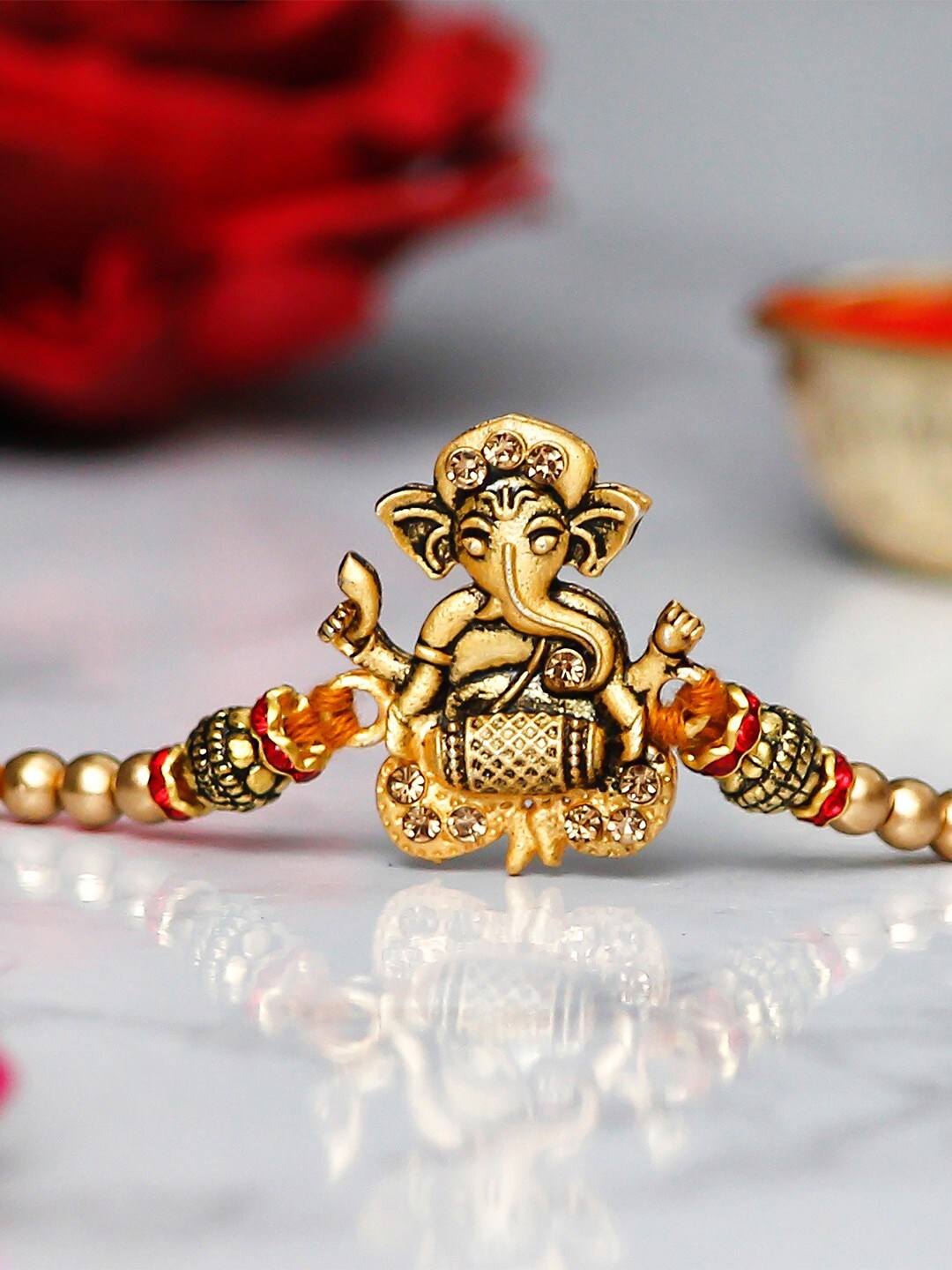

eCraftIndia Gold-Toned & Red Designer Ganesha Playing Dholak Rakhi