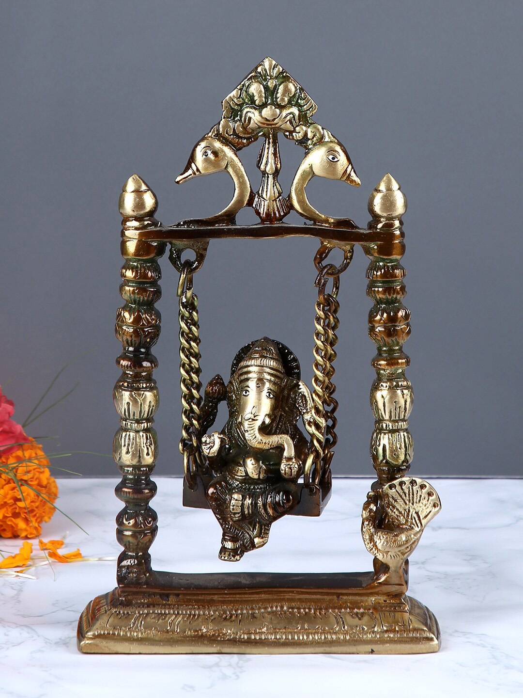 

Aapno Rajasthan Brown & Gold-Toned Brass Lord Ganesh in Jhula Showpiece