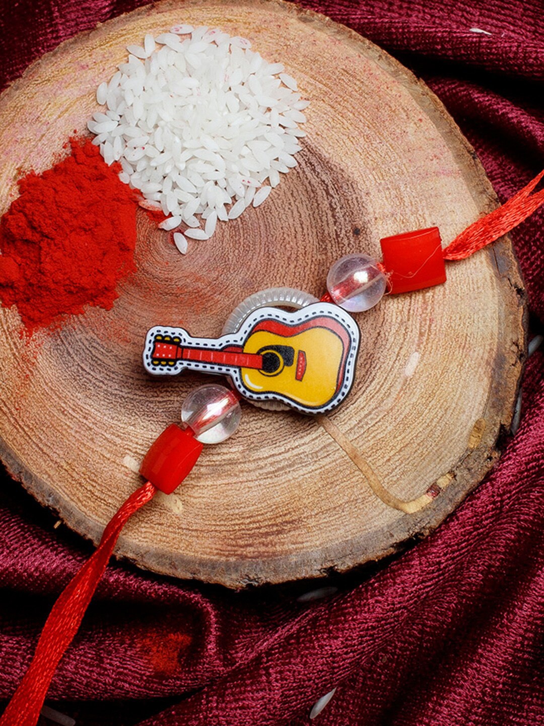 

Shoshaa Kids Red & Yellow Guitar-Shaped Rakhi With Roli Chawal
