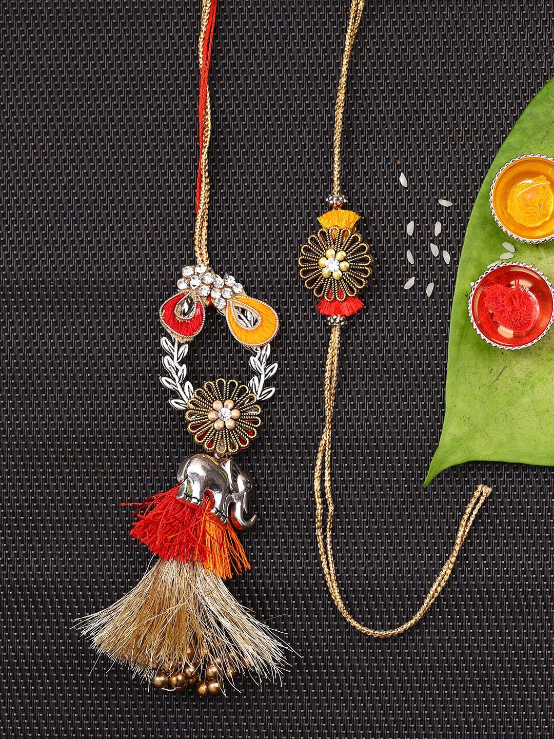 

Aapno Rajasthan Unisex Set Of 2 Gold-Coloured & Orange Stone-Studded Thread Work Bhaiya Bhabhi Rakhis