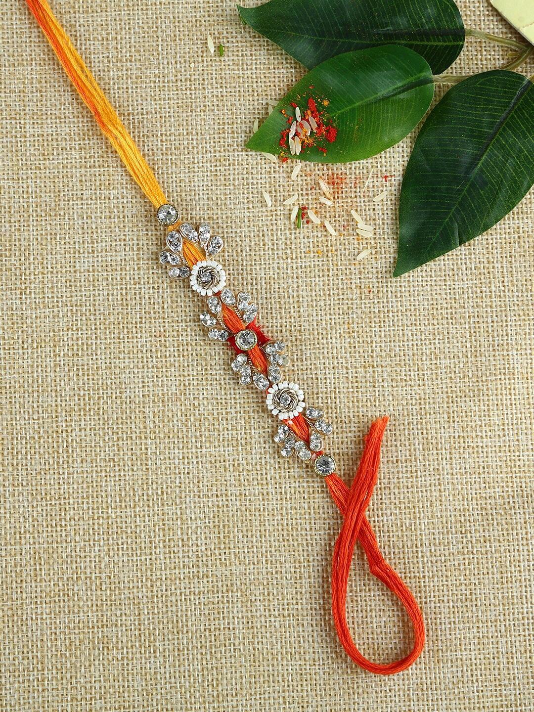 

Aapno Rajasthan SIlver-Toned & Orange Stone Work Handcrafted Mauli Rakhi