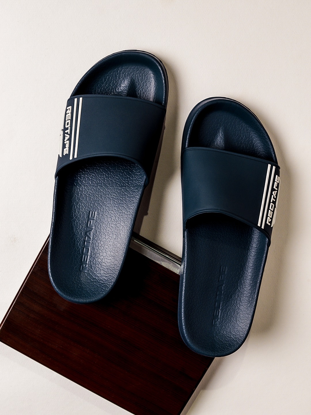 

Red Tape Men Navy Blue & White Printed Rubber Sliders