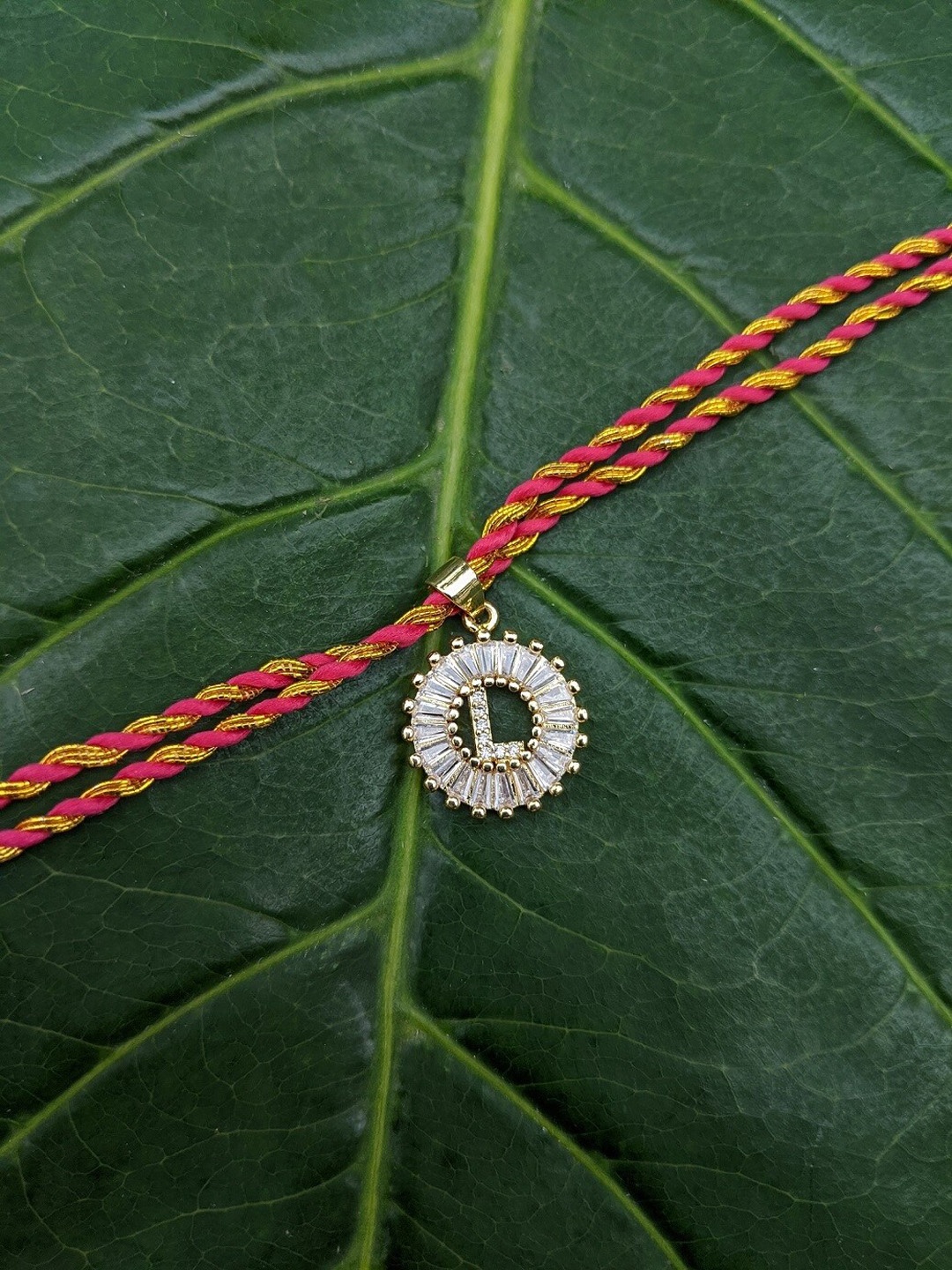 

Digital Dress Room Gold-Plated Orange & White AD-Studded L Alphabet Customized Thread Rakhi