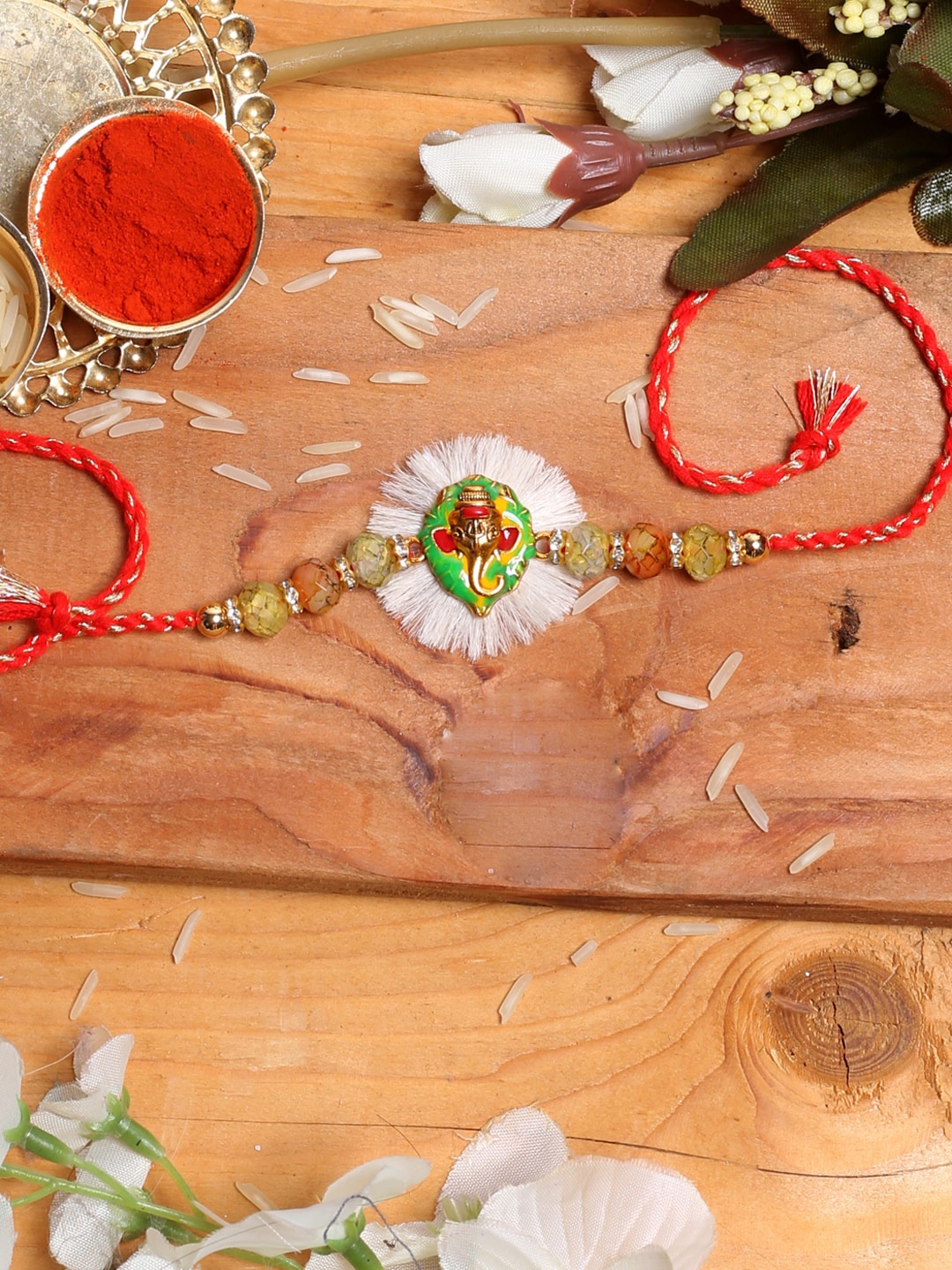 

Aapno Rajasthan Green & Red Lord Ganesha on Leaf Embellished Rakhi