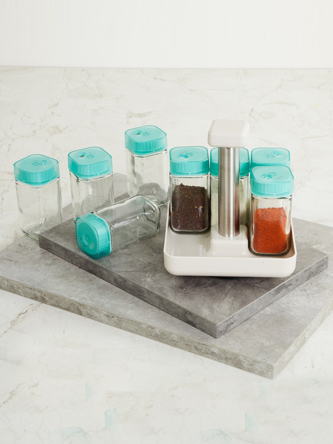 

Home Centre Set Of 8 Transparent & Blue Spice Bottles With Rack