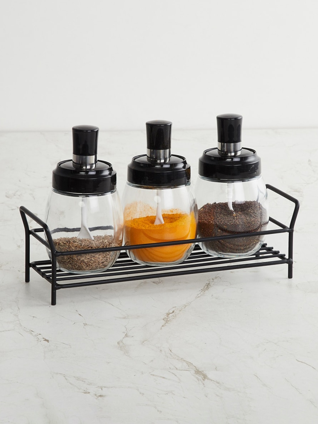 

Home Centre Transparent Glass Spice Jar with Metal Stand