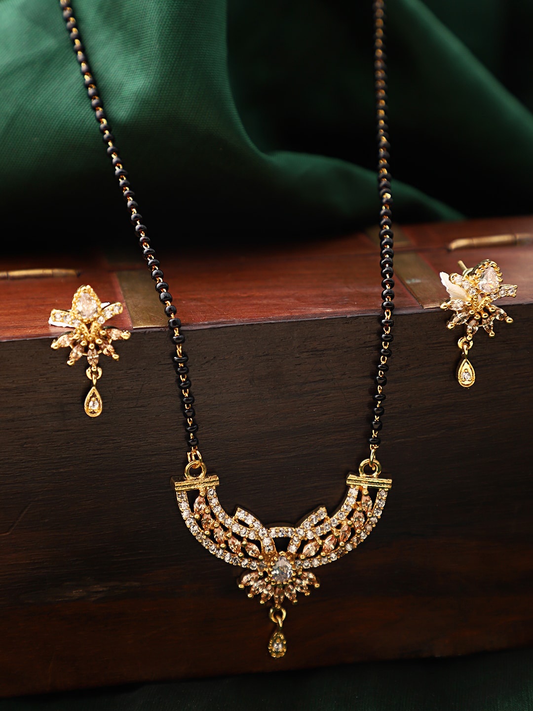 

ANIKAS CREATION Gold-Plated Black & White Beaded & Stone-Studded Mangalsutra With Earrings