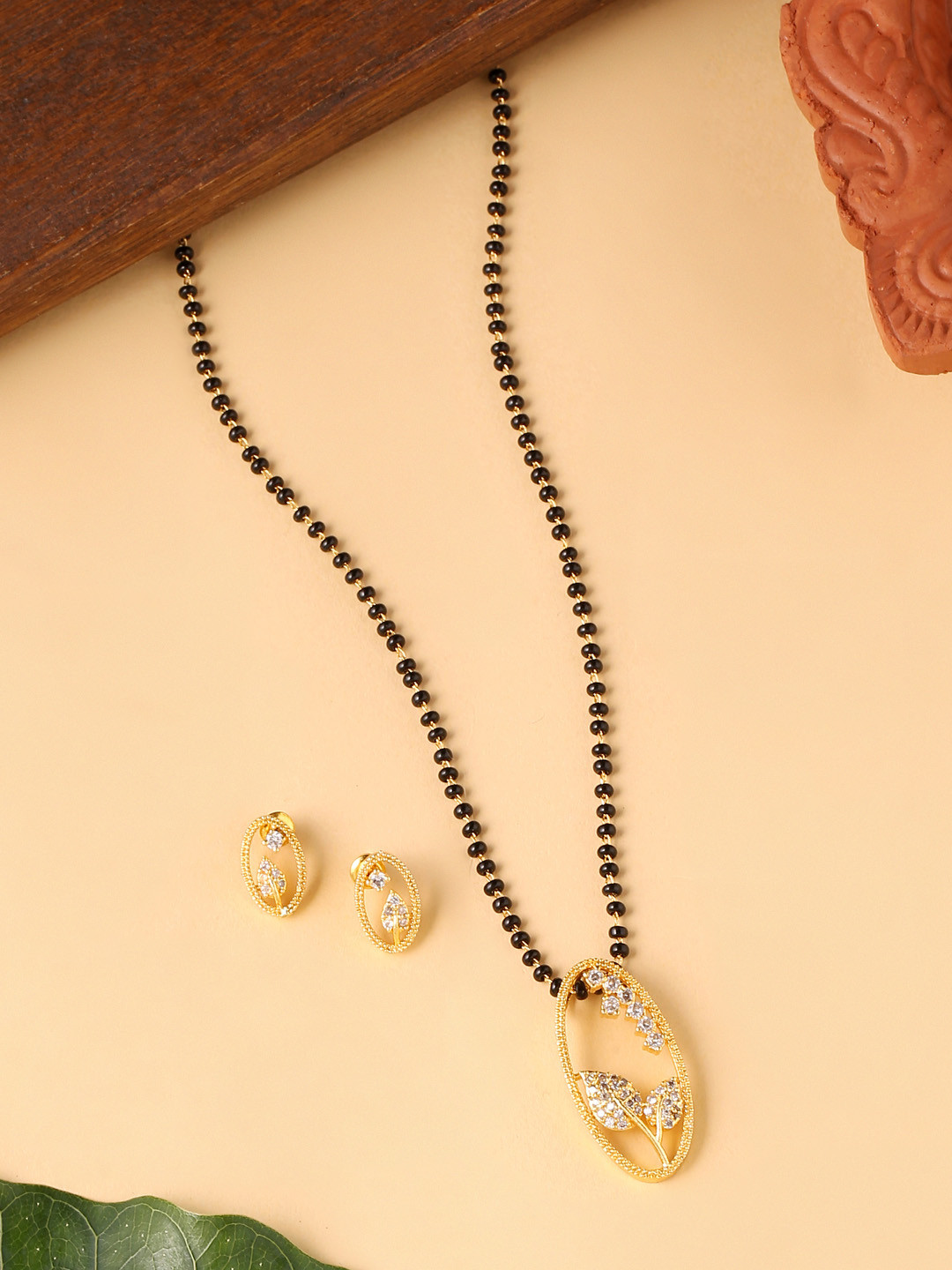 

VIRAASI Gold-Plated White Stone Studded & Black Beadded Mangalsutra & Earrings Set
