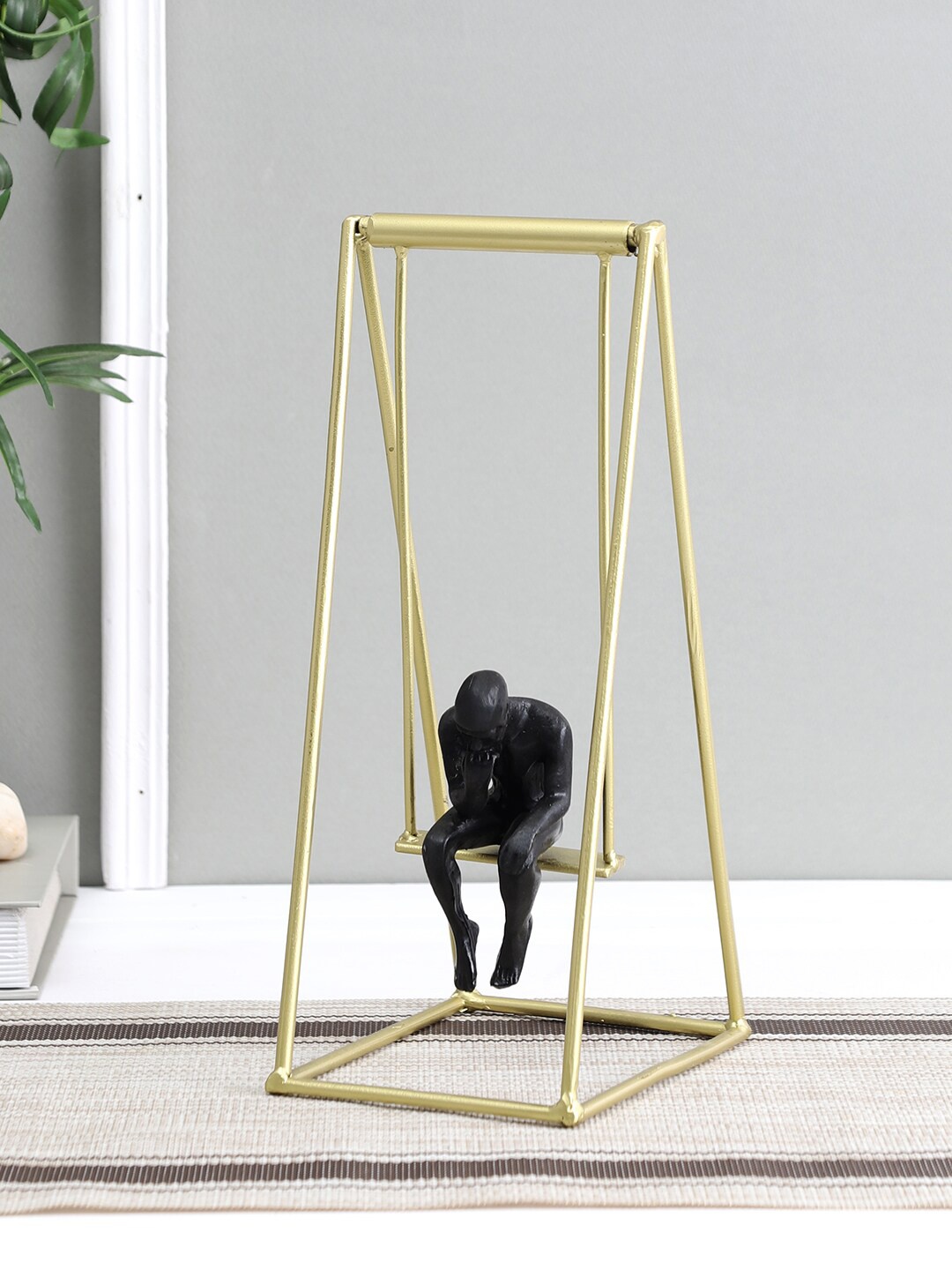 

Aapno Rajasthan Gold-Toned & Black Man On Swing Showpiece