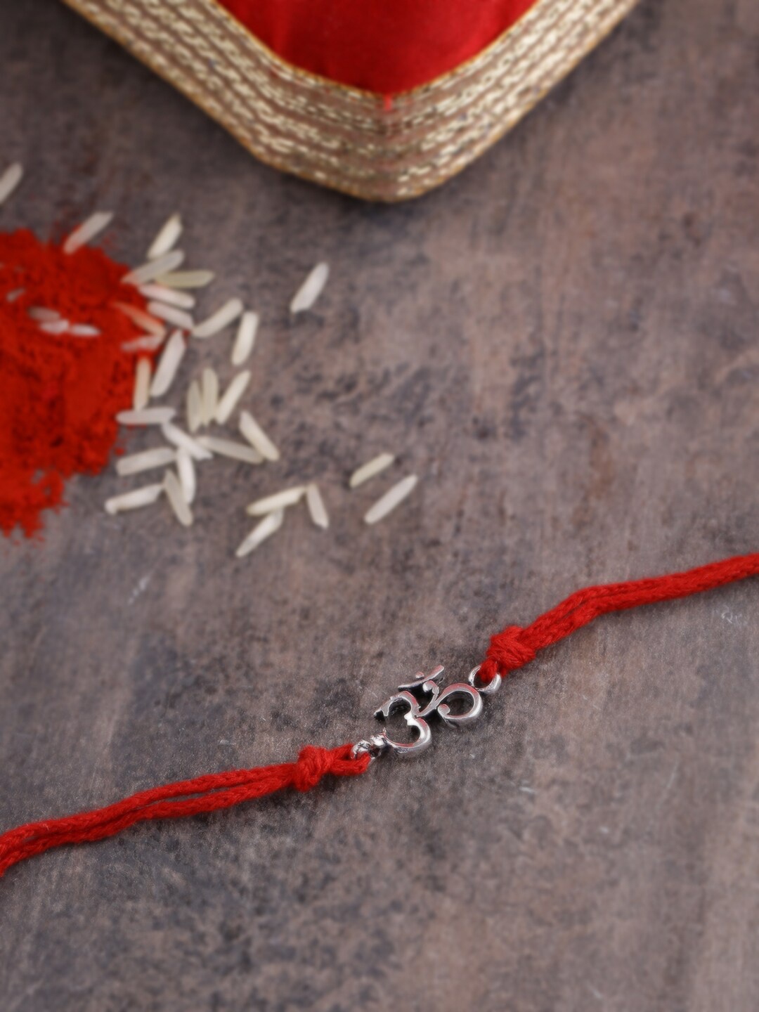 

ADORN by Nikita Ladiwala Sterling Silver-Plated Red Om Shaped Rakhi With Roli Chawal