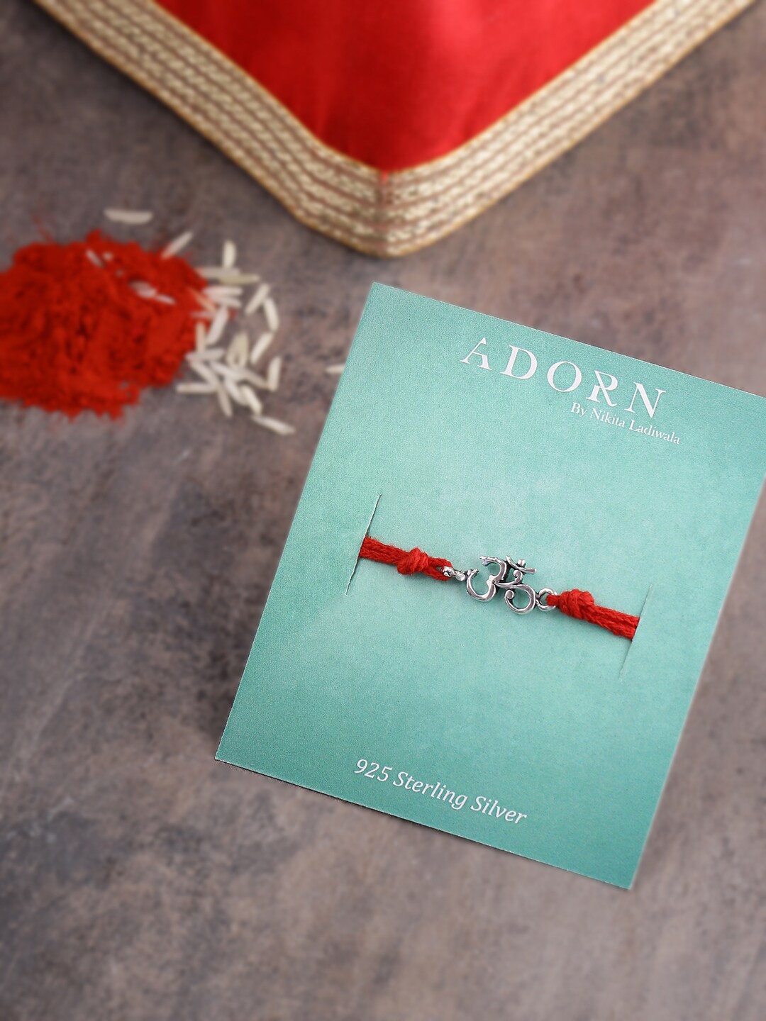 

ADORN by Nikita Ladiwala 92.5 Sterling Silver Om Rakhi With Roli Chawal