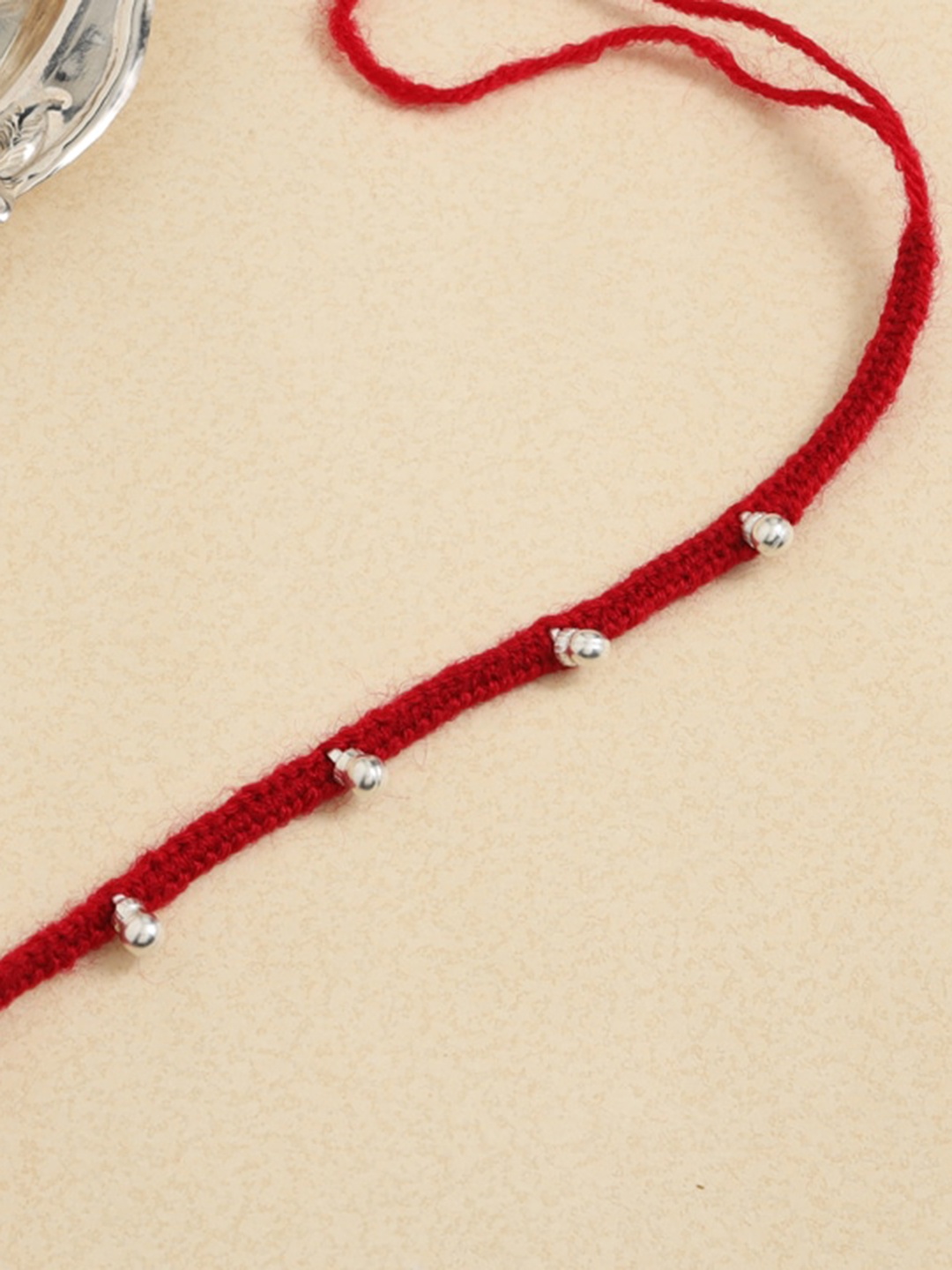 

ADORN by Nikita Ladiwala Red & Silver Toned Woven Design Tie Up Rakhi