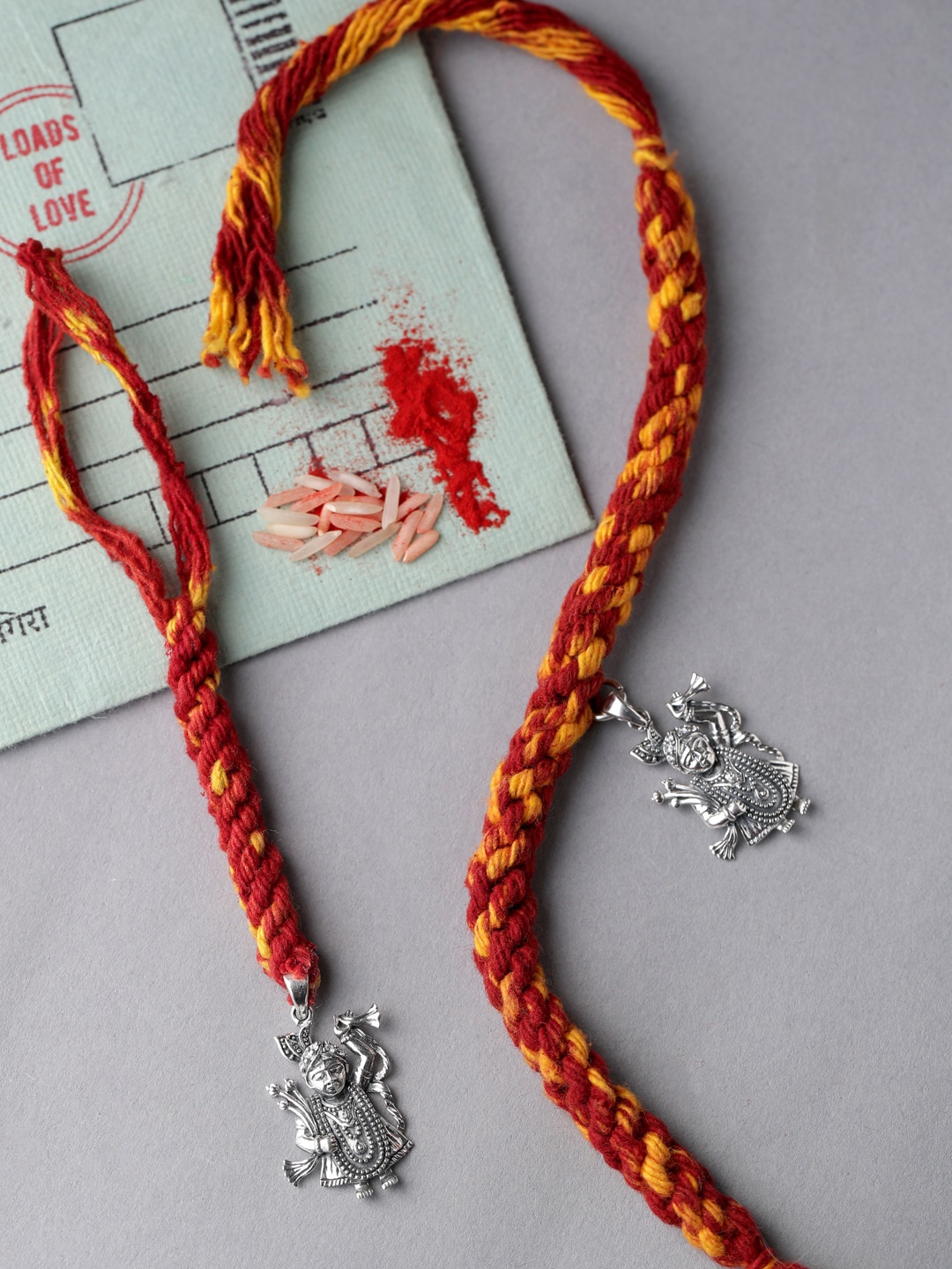 

ADORN by Nikita Ladiwala Unisex Silver-Toned & Red Rakhi