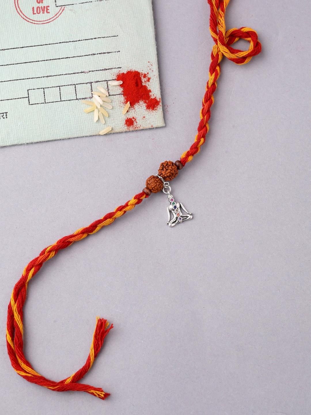 

ADORN by Nikita Ladiwala Silver-Toned & Red Human Charm Rakhi