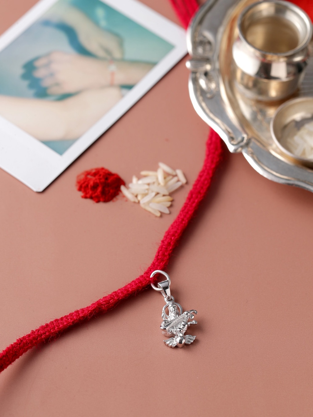 

ADORN by Nikita Ladiwala Unisex Silver-Toned & Red Rakhi