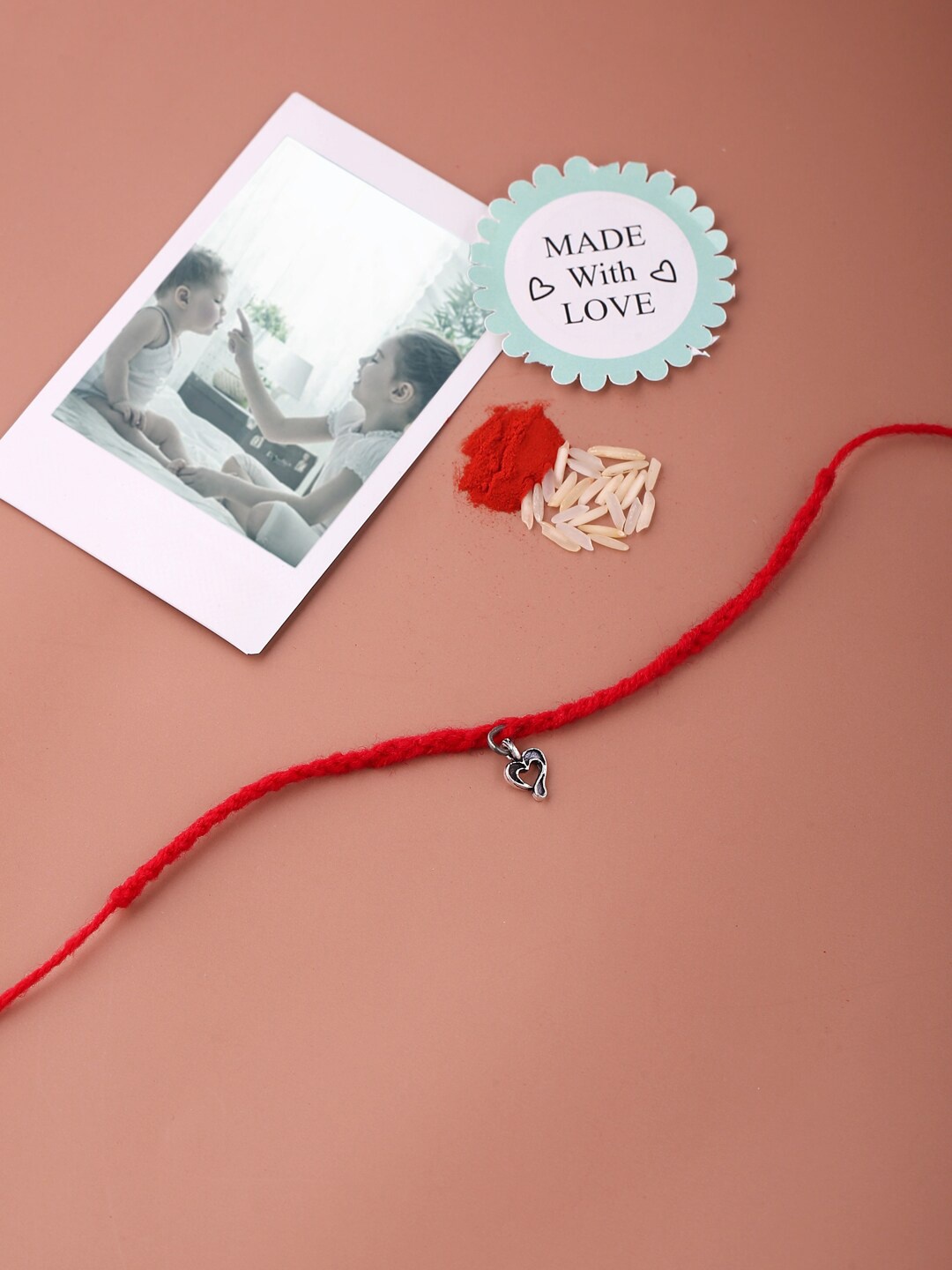 

ADORN by Nikita Ladiwala Silver-Toned & Red Heart Charm Rakhi With Roli Chawal