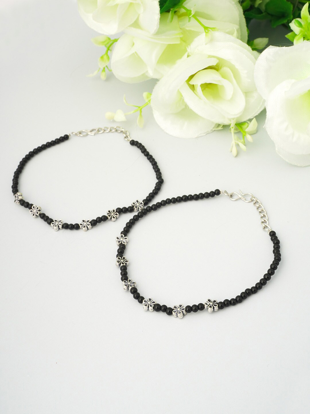 

Urmika Women Set Of 2 Oxidised Black Beaded Flower Anklets