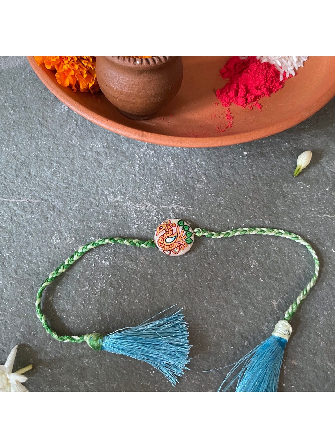 

Mitali Jain White and Green Tanjore Studded Rakhi