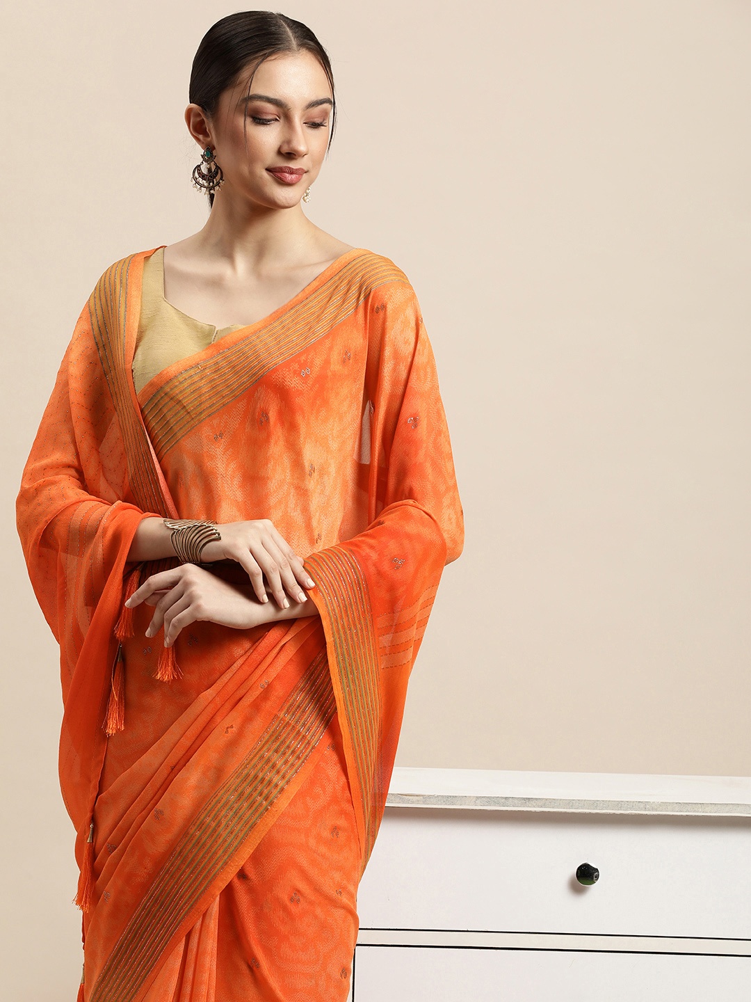 

Triveni Orange & Gold Ethnic Motifs Zari Pure Georgette Celebrity Saree