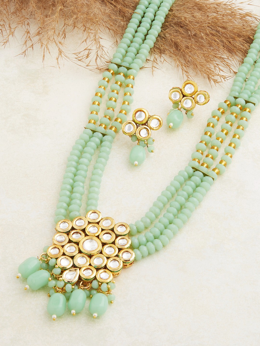 

Zaveri Pearls Gold-Plated White & Green Stone-Studded & Pearl Beaded Jewellery Set
