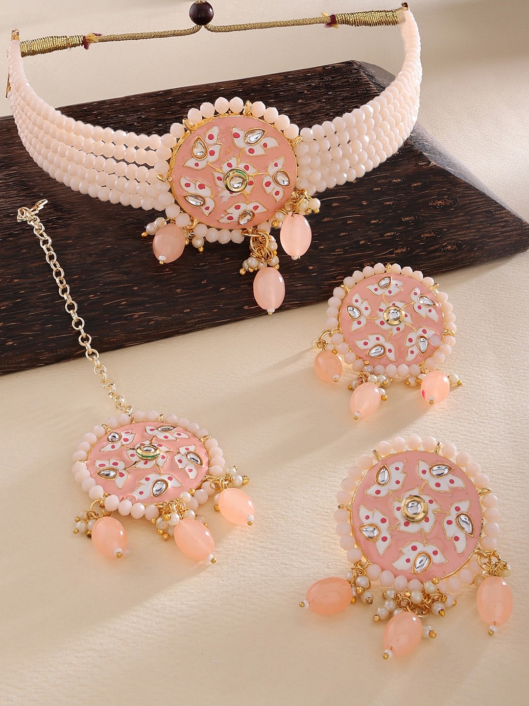 

Zaveri Pearls Gold-Plated Peach coloured & White Stone Studded & Beaded Jewellery Set