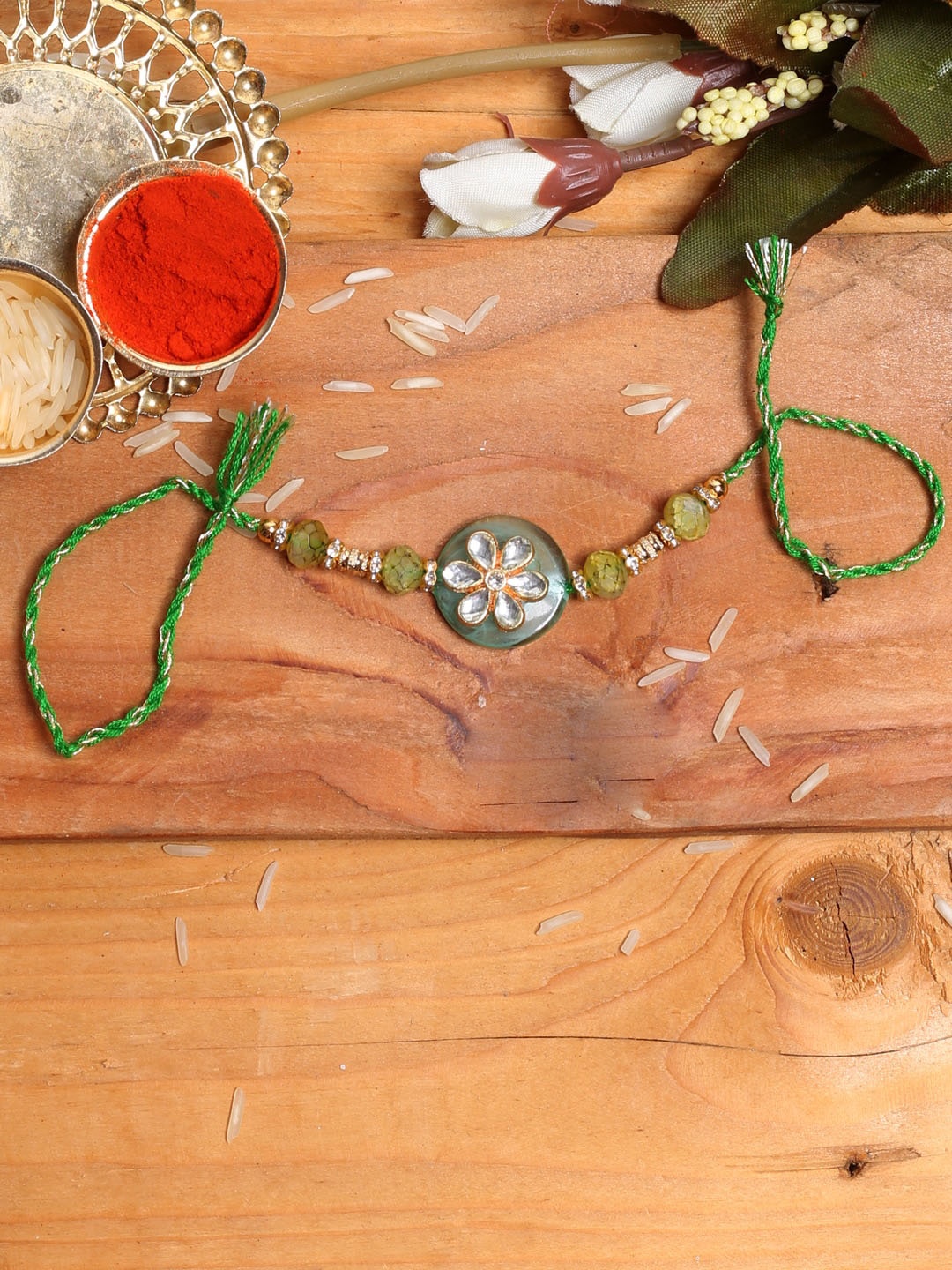 

Aapno Rajasthan Grey & Green Raisin Kundan Studded Meena Floral Rakhi