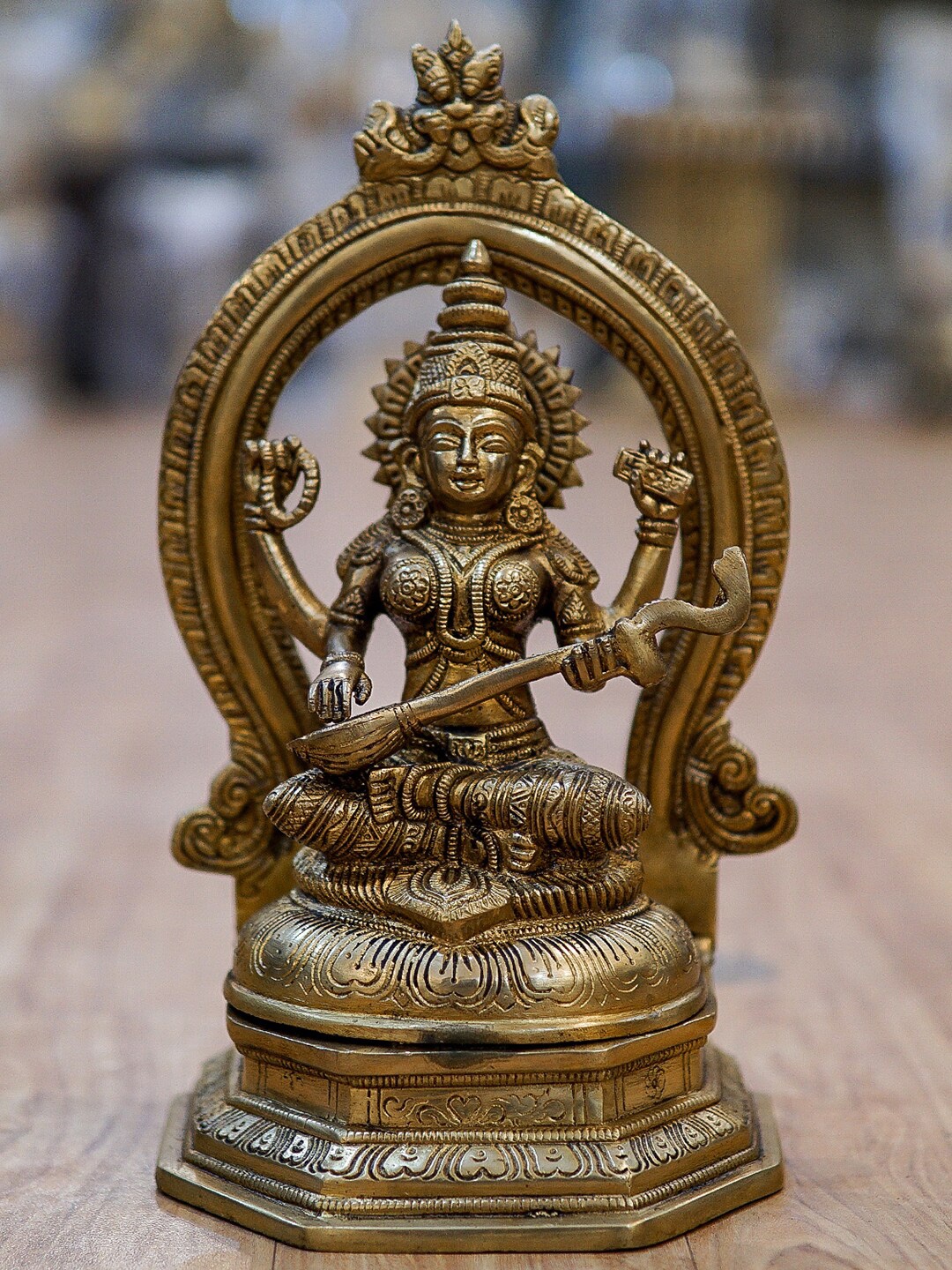 

StatueStudio Gold-Toned Textured Saraswati Statue With Frame Showpiece