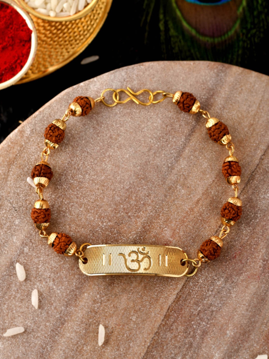 

Shoshaa Brown & Gold Toned OM with redraksha beaded bracelet Rakhi