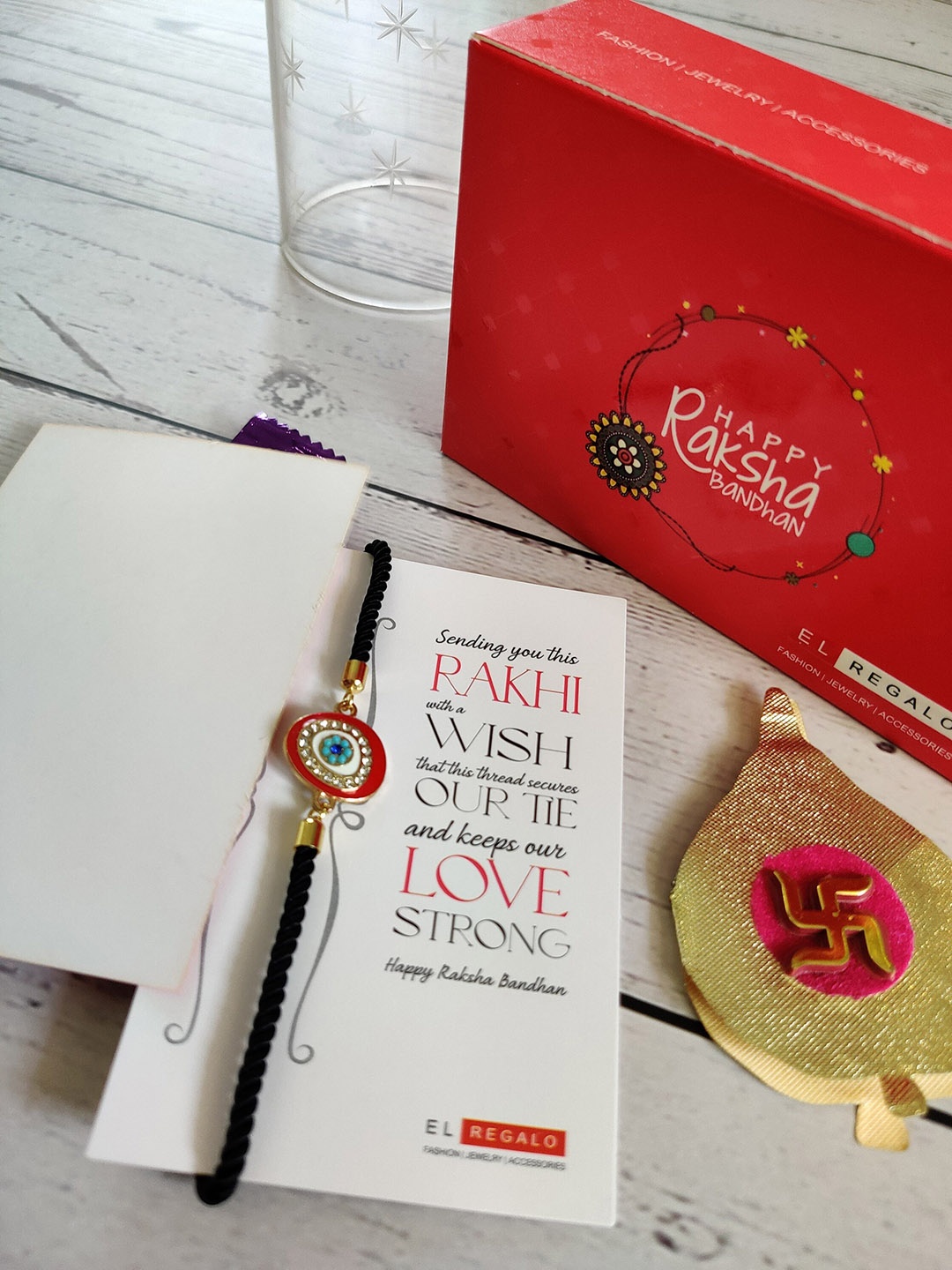 

EL REGALO Gold-Toned Red & White Stone Studded Wraparound Rakhi With Roli Chawal & Raksha Bandhan Greeting Card