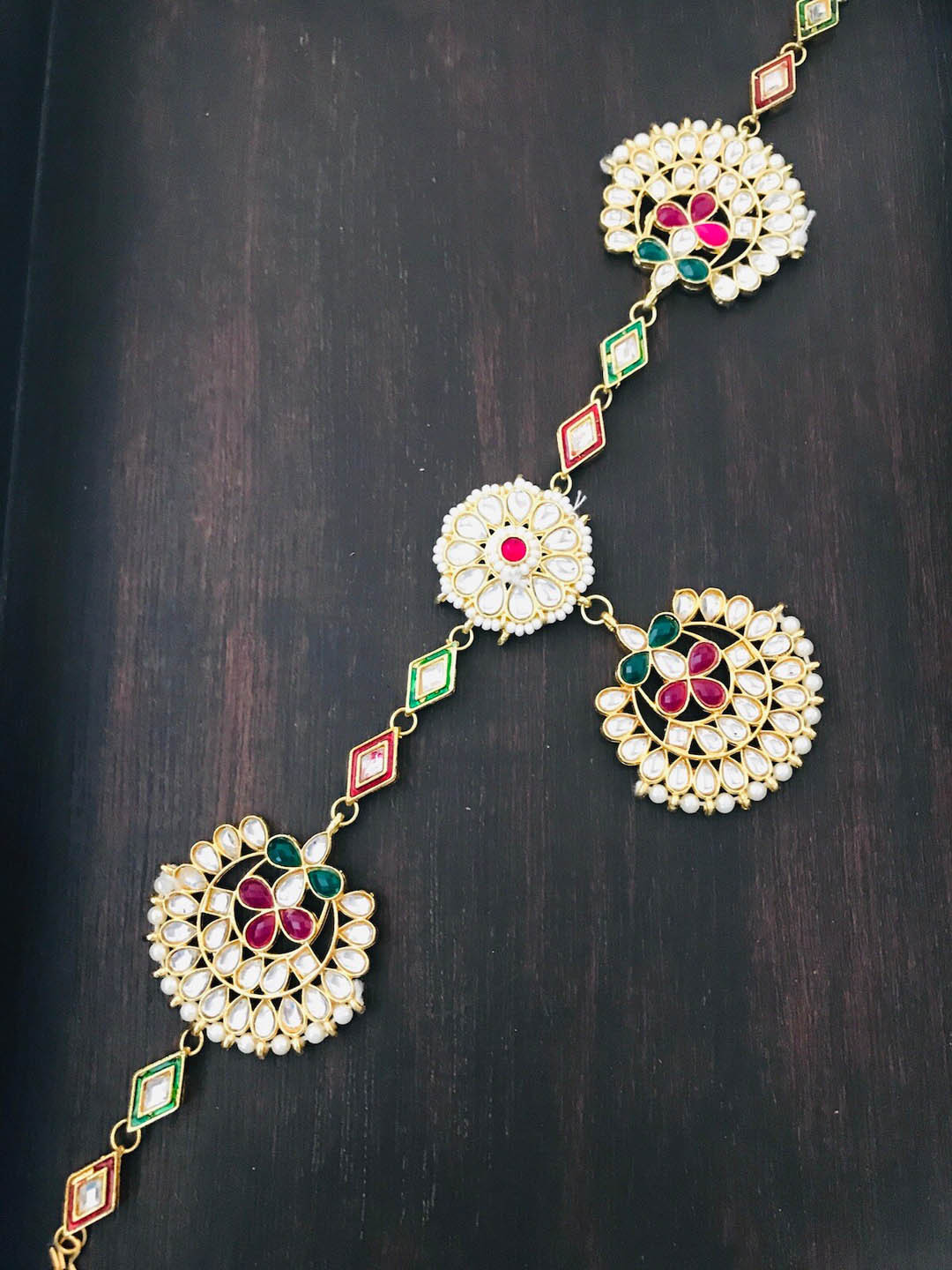 

The Opal Factory Gold Plated & Red Studded Floral Sheeshphool