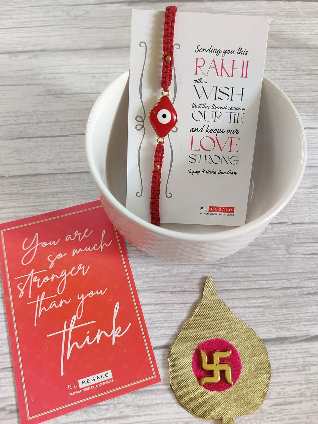 

EL REGALO Evil Eye Rakhi Combo for Bhai With Roli Chawal Shagun and Greeting Card, Red