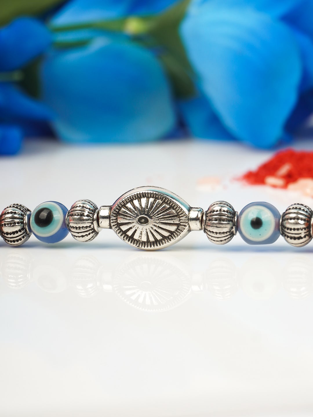 

Ferosh Men Silver-Toned and Blue Thread Rakhi With Roli Chawal