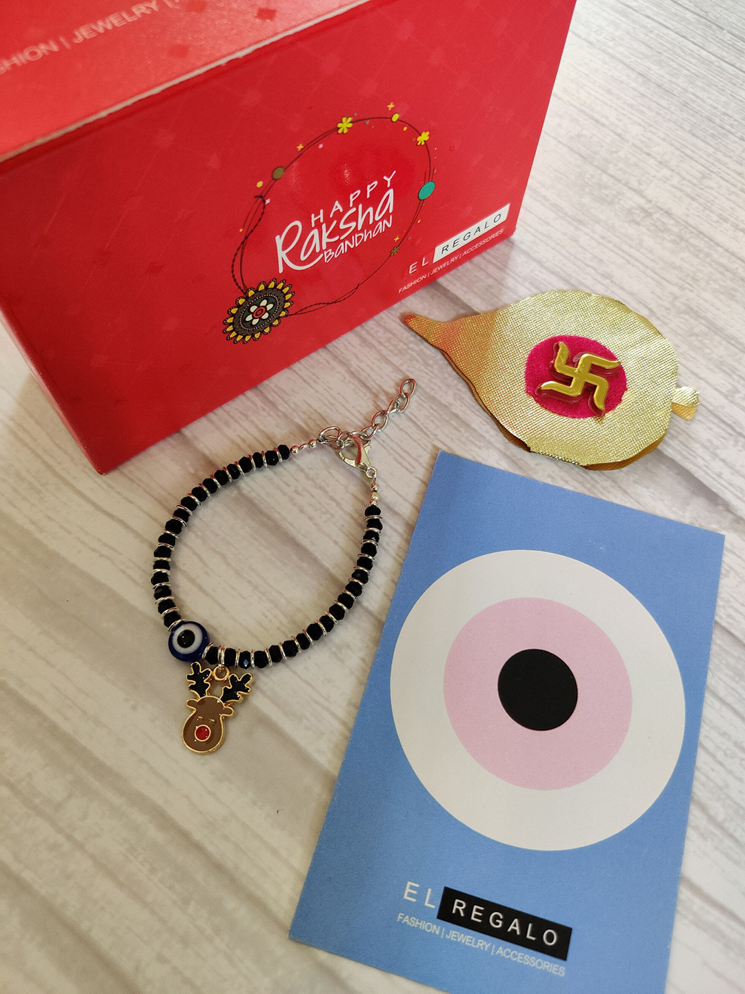 

EL REGALO Kids Red Nazaria Rakhi Combo with Greeting Card & Roli Chawal Shagun