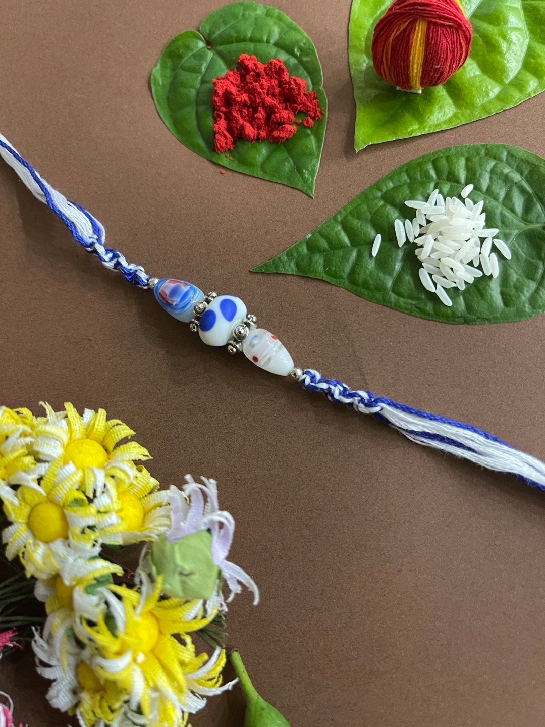 

Digital Dress Room Men Blue & White Beaded Rakhi With Roli