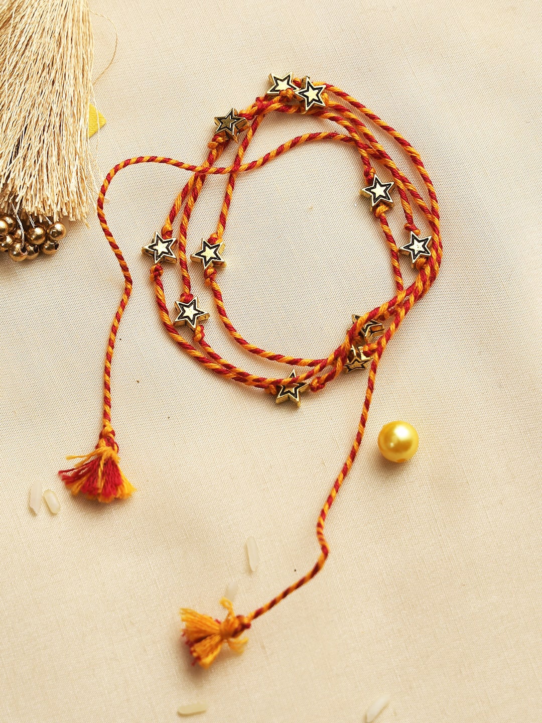 

Aapno Rajasthan Red & Yellow Starry Beaded Rakhi