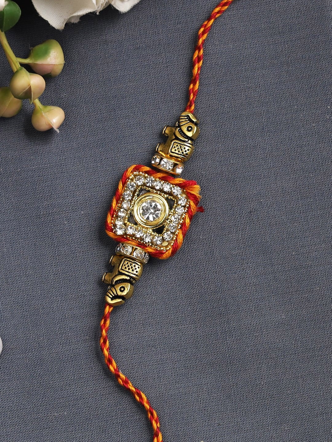 

Aapno Rajasthan Gold-Toned & Red Square Shaped Elephant Rakhi