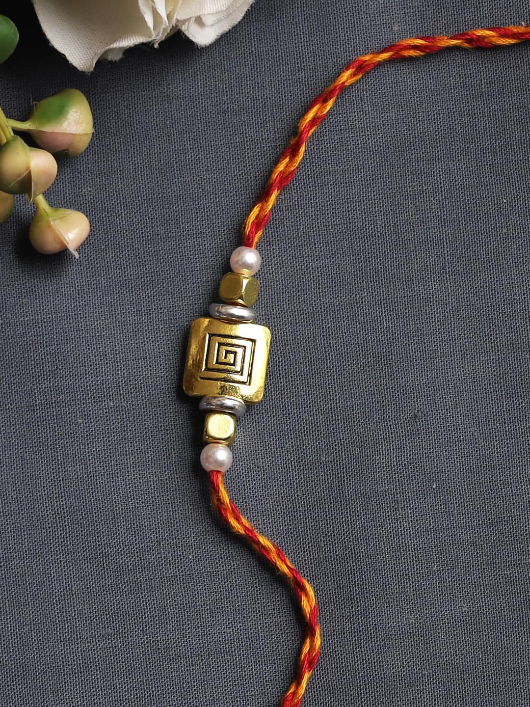 

Aapno Rajasthan Red & Gold-Toned Square Spiral Rakhi