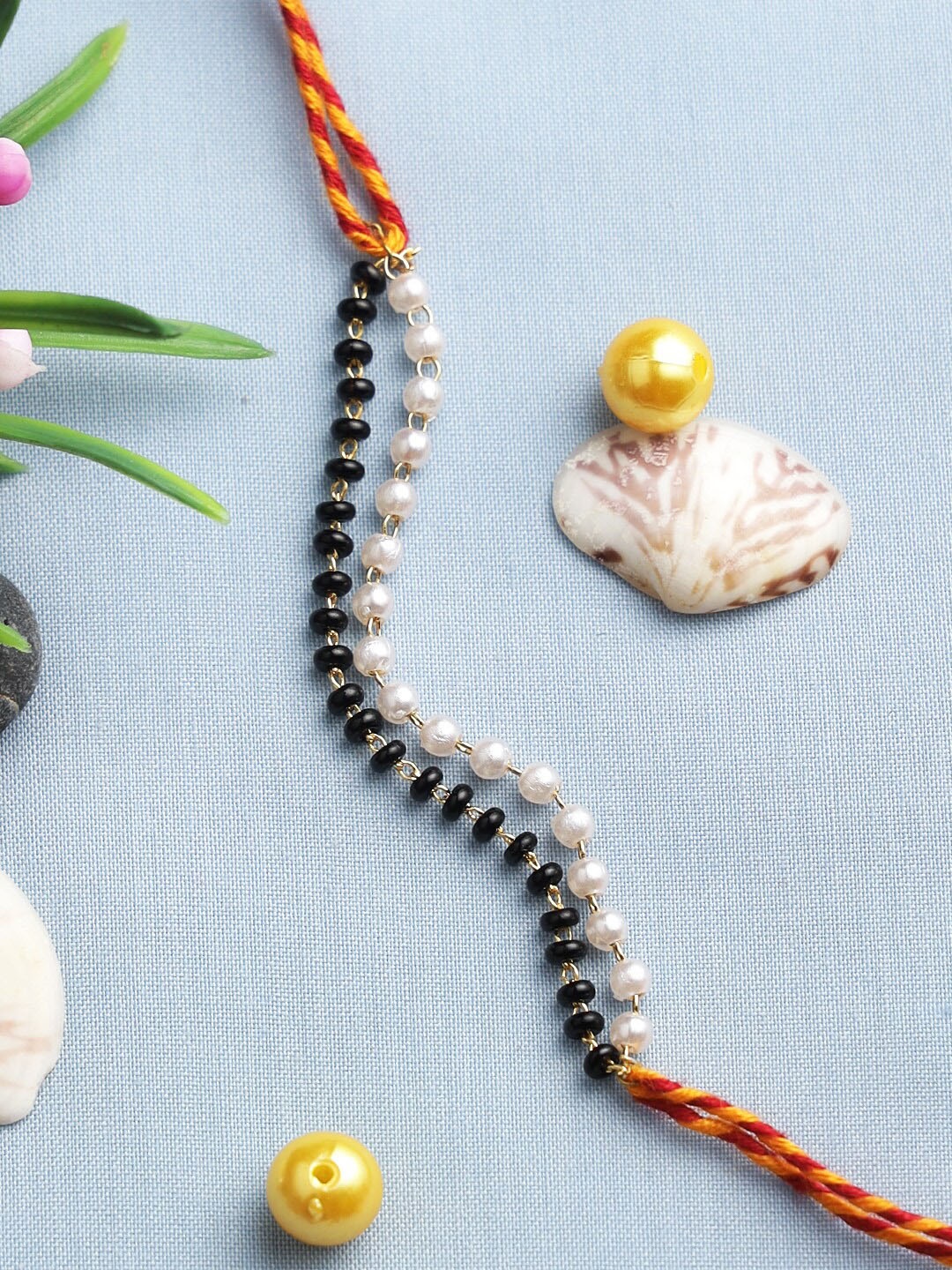 

Aapno Rajasthan Black and White Beaded Chain Rakhi